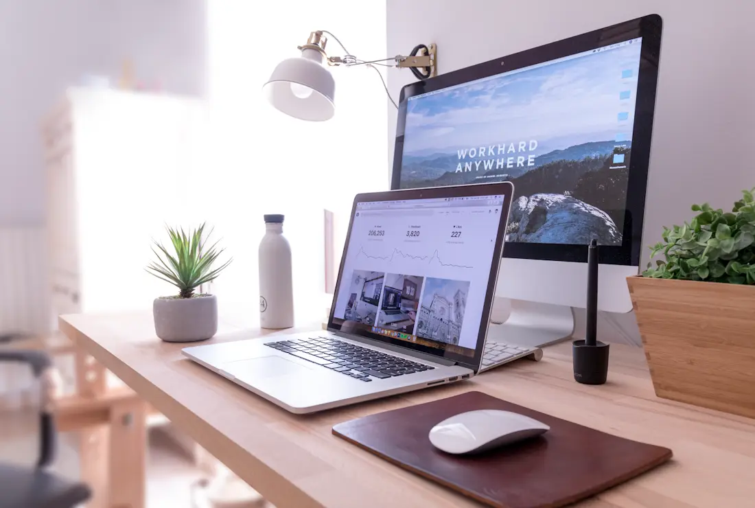 A working desk with laptop and monitor