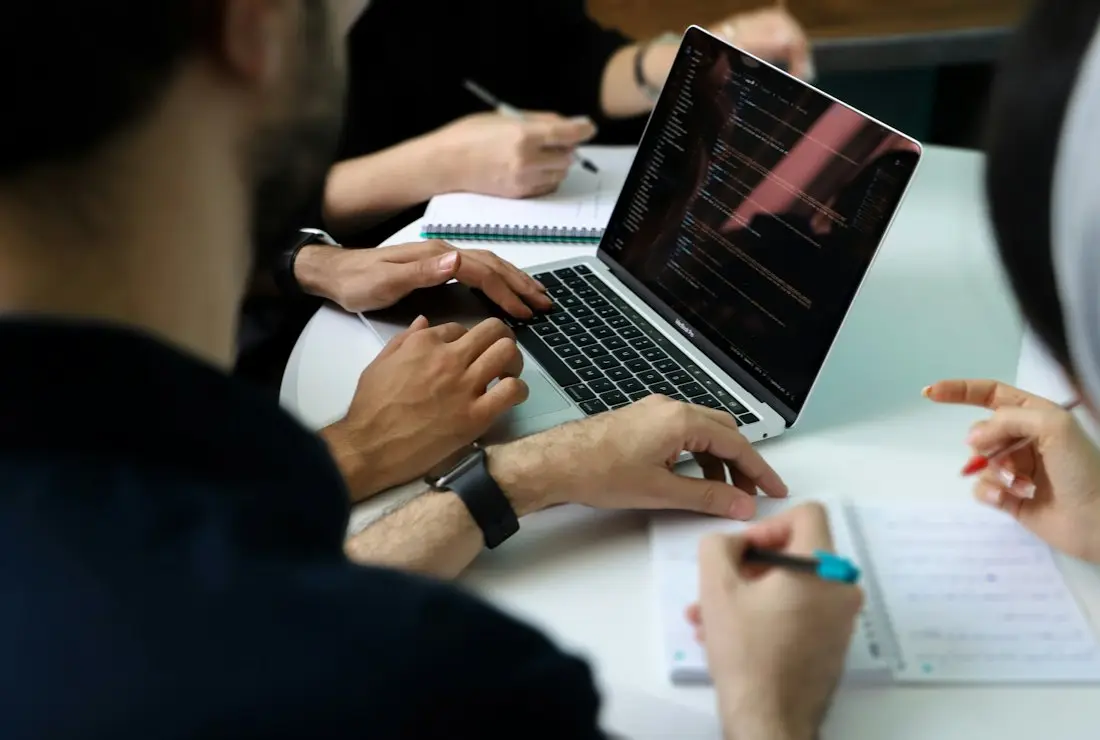 Colleagues gathered around a laptop