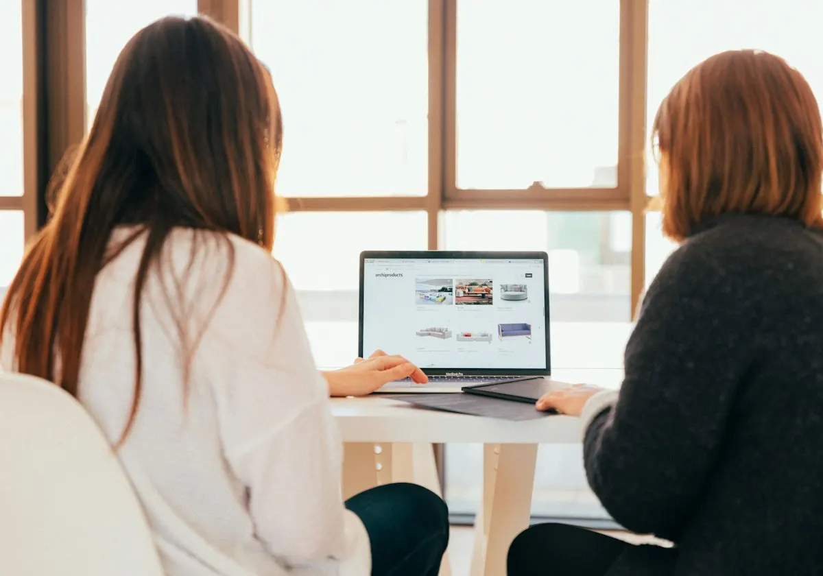 Colleagues reviewing work together on a laptop