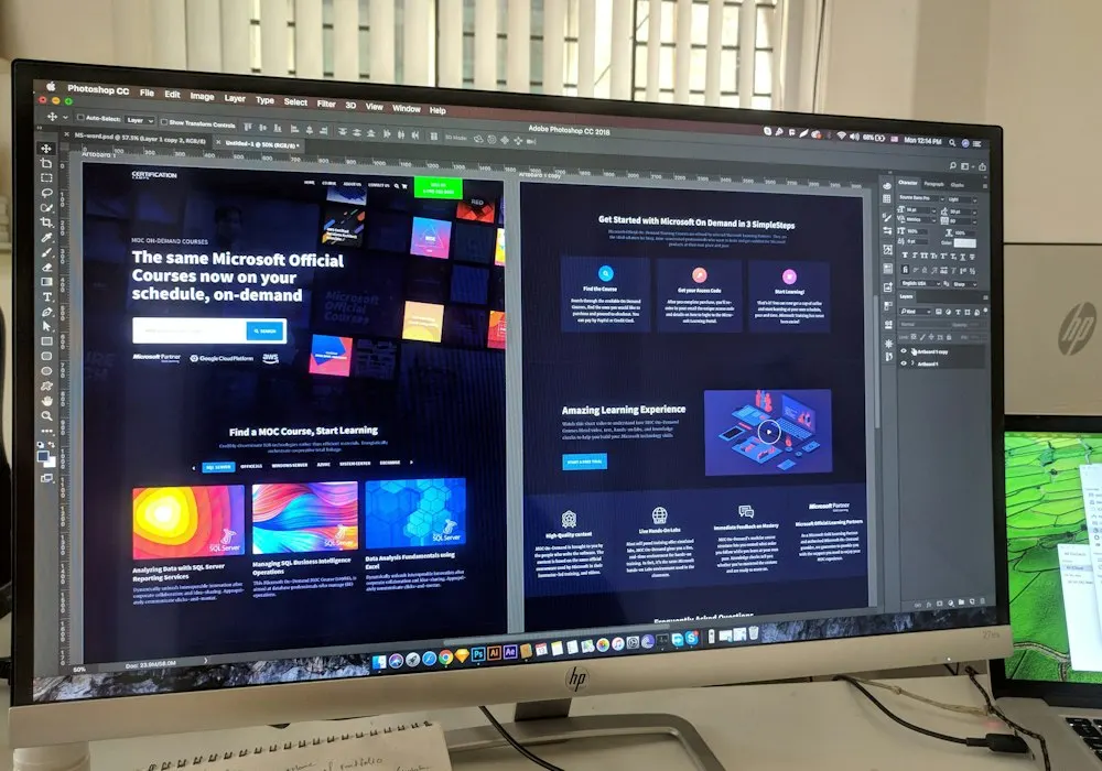 Website layouts and design assets open on a desktop monitor